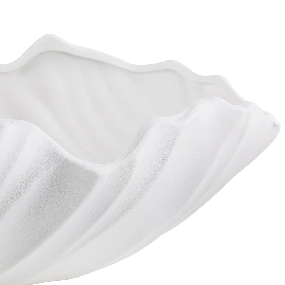 A white ceramic vase with an abstract and wave-like design.