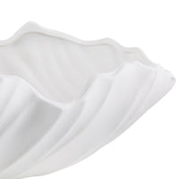 A white ceramic vase with an abstract and wave-like design.