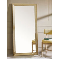 Full-length mirror with a gold frame in a room with a chair and table.
