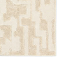 Beige and white geometric patterned rug on a plain background
