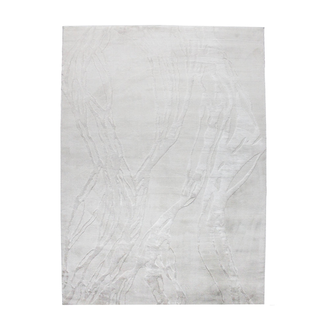 A power loomed Mila Area Rug in off white with a polypropylene and polyester construction and jute backing.