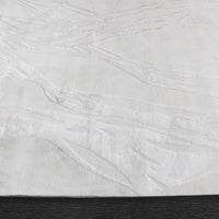 A power loomed Mila Area Rug in off white with a polypropylene and polyester construction and jute backing.
