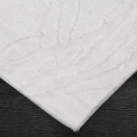 A power loomed Mila Area Rug in off white with a polypropylene and polyester construction and jute backing.