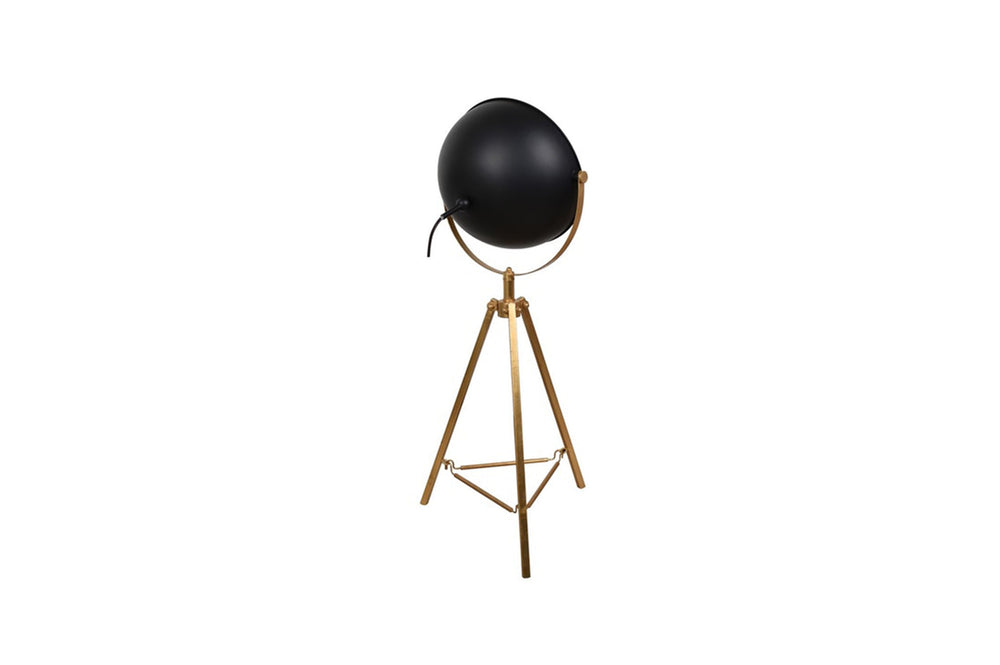 A mid-century modern table lamp with antique brass plated iron base and clear glass element, topped with an off-white shade.