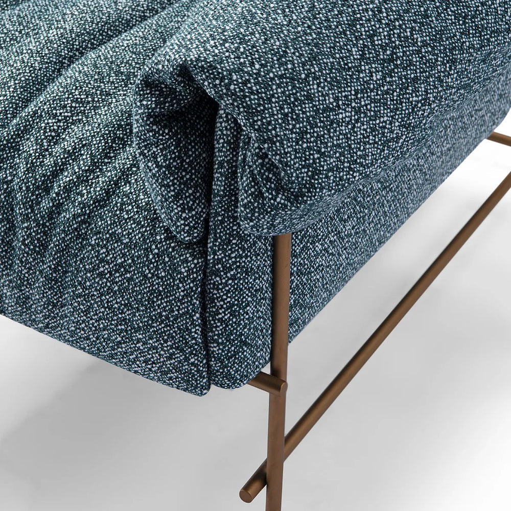 Blue textured sofa with bronze legs on a light gray background