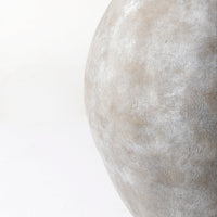 Close-up of a textured stone vase on a white background