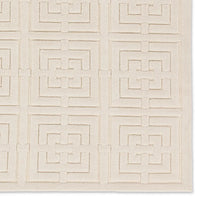 A beige area rug with a geometric pattern