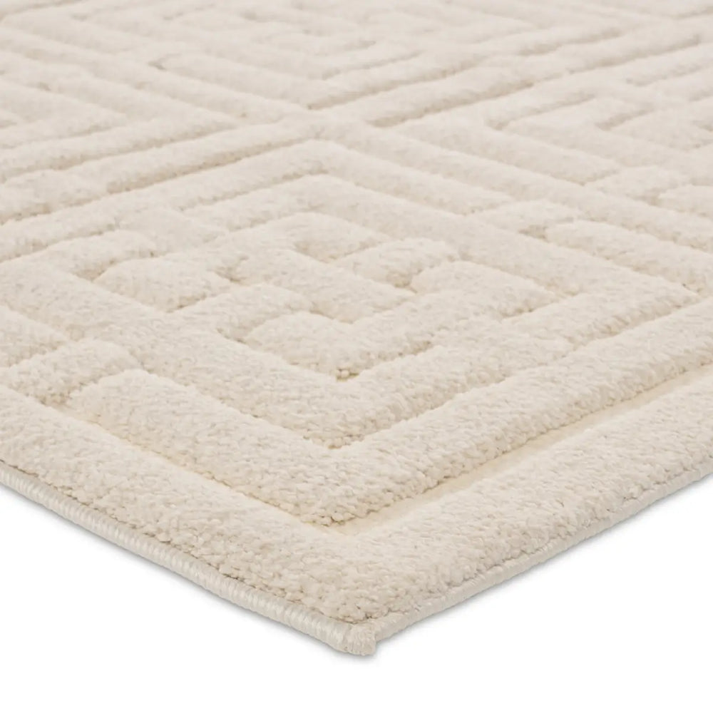 A beige area rug with a geometric pattern
