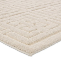 A beige area rug with a geometric pattern