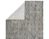 A rectangular wool area rug with a geometric pattern in gray, beige, and other colors.