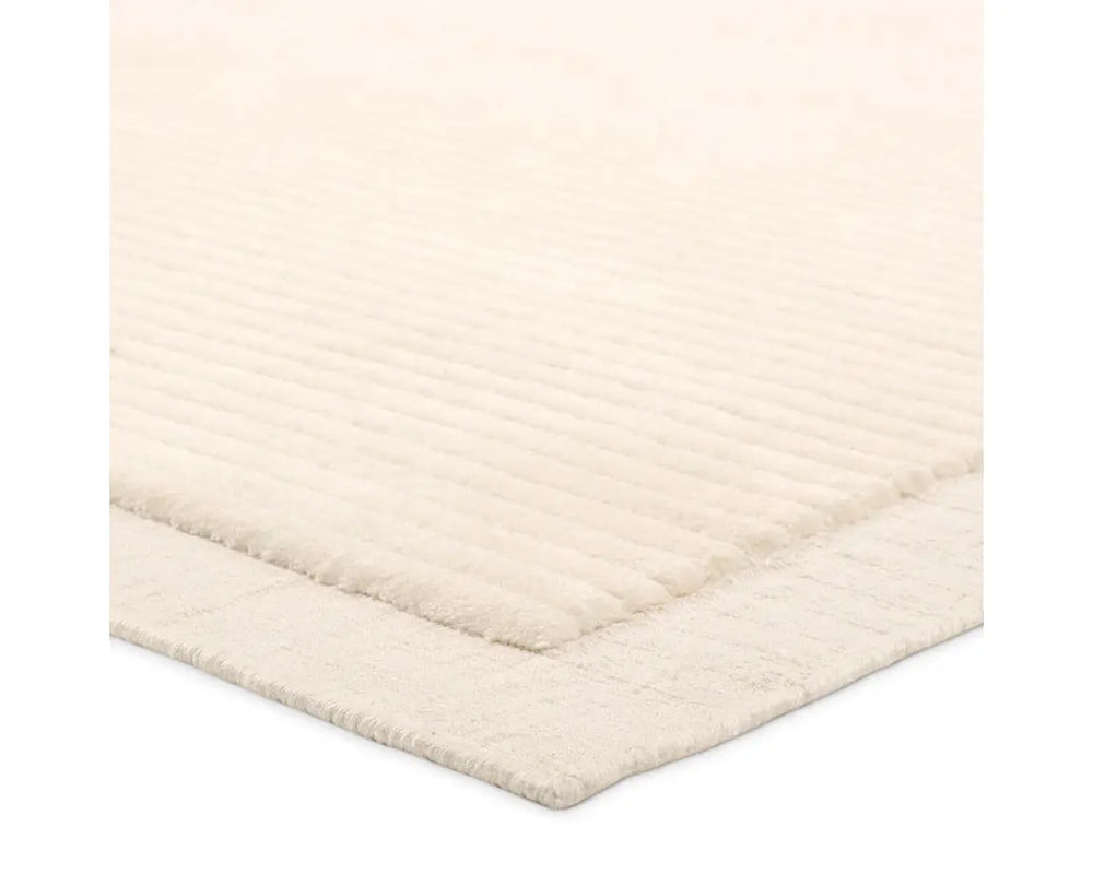 A beige, solid-colored area rug with a visible texture.
