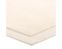 A beige, solid-colored area rug with a visible texture.
