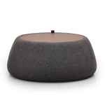 A gray fabric ottoman with a round top and a cylindrical body, placed against a white background.