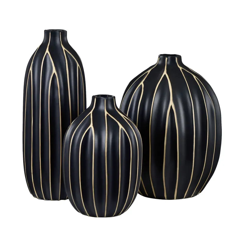 A set of three black vases with vertical golden stripes.