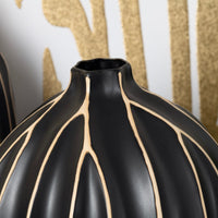 A black vases with vertical golden stripes.