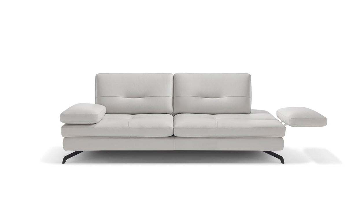 A white upholstered sofa with a modern, simplistic design, accompanied by a matching white ottoman.