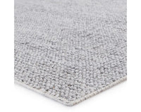 A rectangular, solid gray area rug with a textured weave.