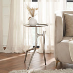 Small round table with decorative vase next to a beige sofa in a bright room.