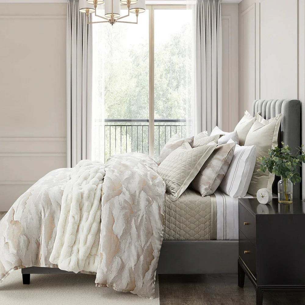 Neatly made bed with decorative pillows and a floral-patterned throw in a well-lit bedroom.