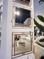 Decorative wall mirrors with gold frames on a white wall.