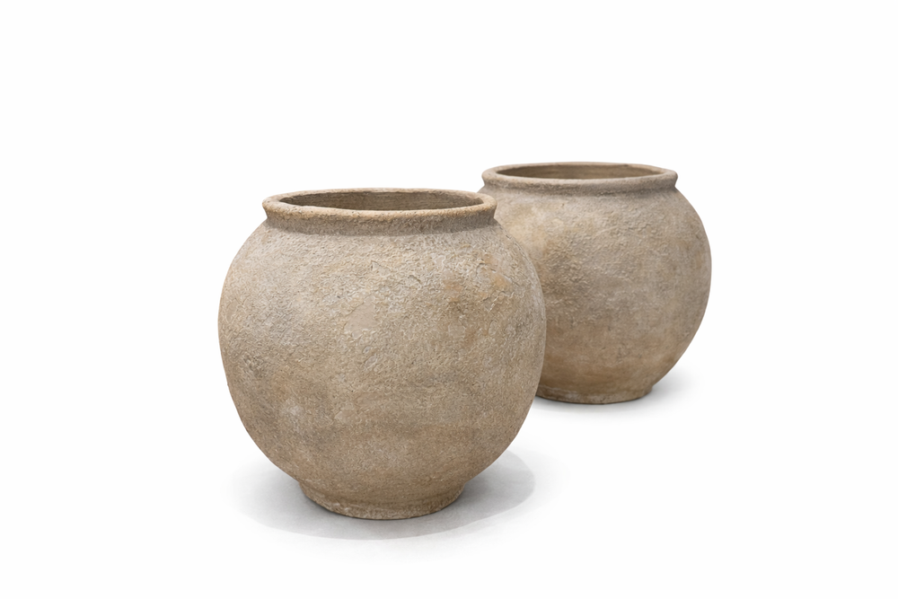 Two beige ceramic pots on a white background