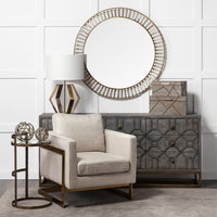 A decorative tree branch orb in a rustic gold tone, displayed in a room setting with a chair and lamp, indicating use as a home decor item.