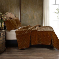 Brown textured quilt on a bed in a bedroom setting with a window and dresser.
