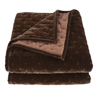 Folded brown quilt on a white background