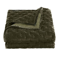 Folded green quilt on a white background