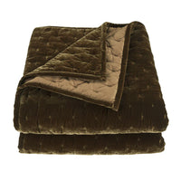 Folded brown quilt on a white background