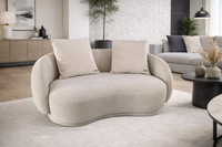 Modern living room with a beige wavy sofa and stylish decor.