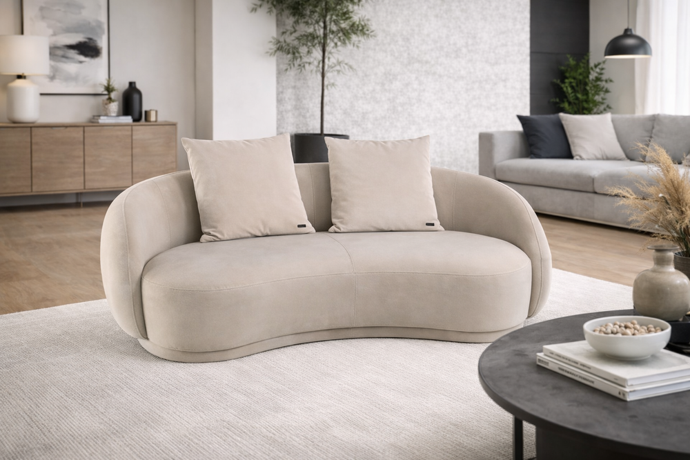 Modern living room with a beige sofa, coffee table, and decorative items.
