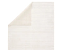 A white, solid color area rug on a plain background.