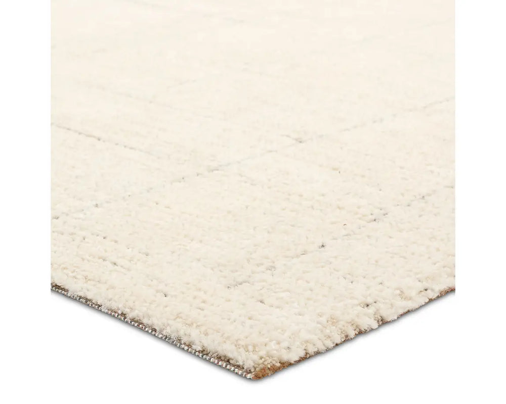 A beige area rug with a geometric pattern.