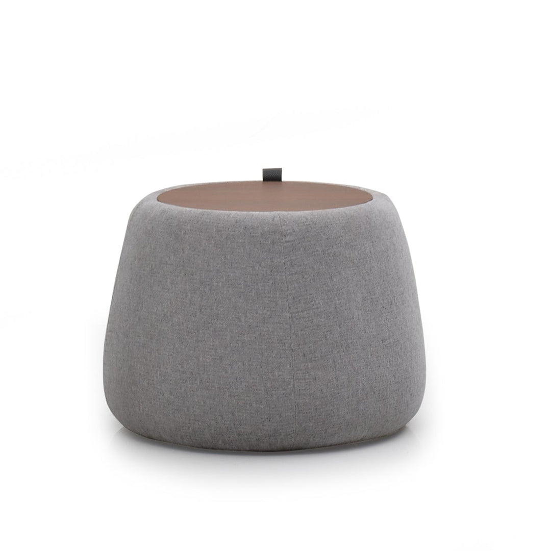 A round gray upholstered Roman ottoman with a cushioned top.
